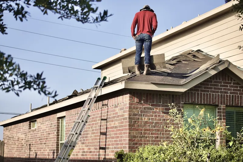 Professional roofer working on a residential roof in Cohasset